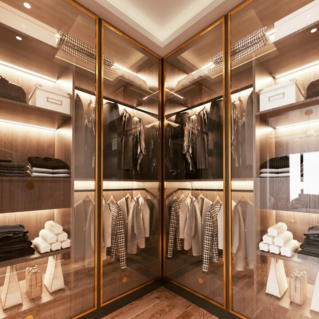 Luxury custom closet with glass doors, built-in lighting, organized clothing, folded items, and storage boxes.